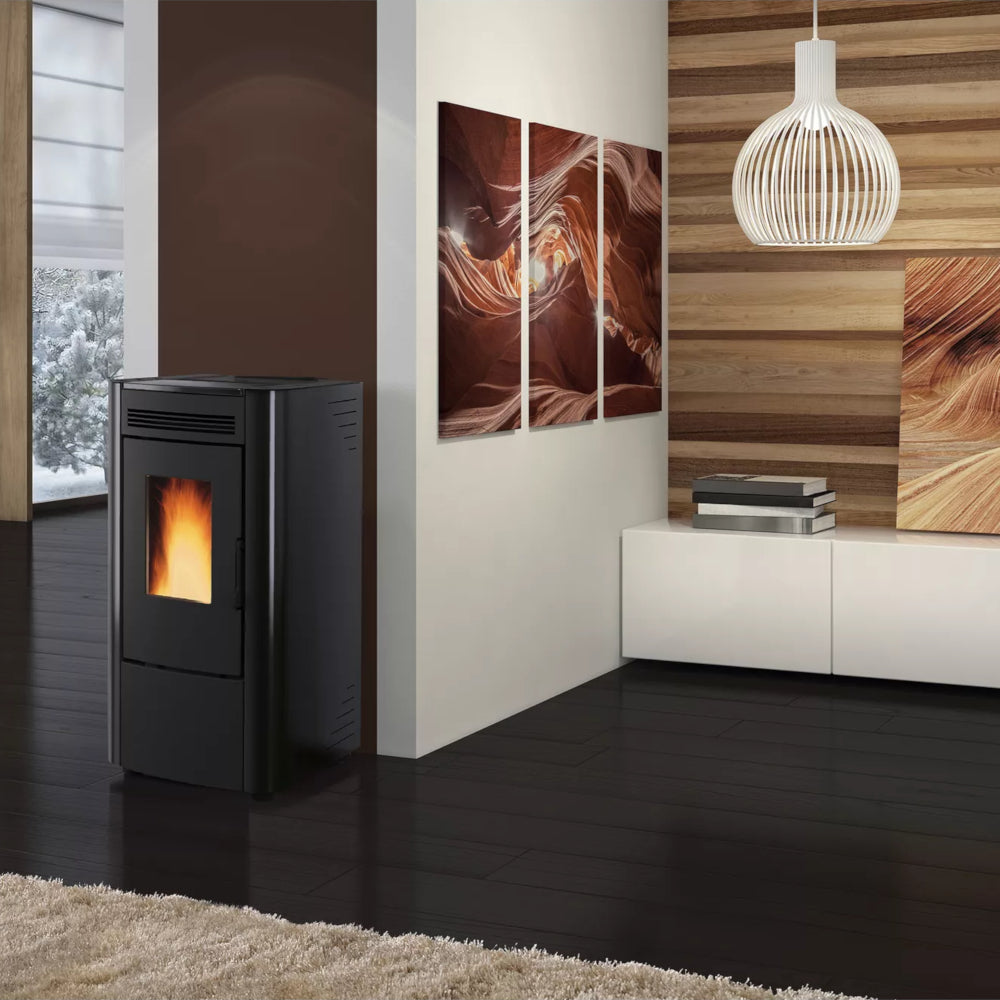 Ambientebild: Extraflame beluefteter Pelletofen KETTY 5.0 in Schwarz mit schwarzer Front, Flamme sichtbar, im modernen Wohnraum mit Holzlamellenwand und Bildern | Klimaworld.com