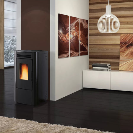 Ambientebild: Extraflame beluefteter Pelletofen KETTY 5.0 in Schwarz mit schwarzer Front, Flamme sichtbar, im modernen Wohnraum mit Holzlamellenwand und Bildern | Klimaworld.com