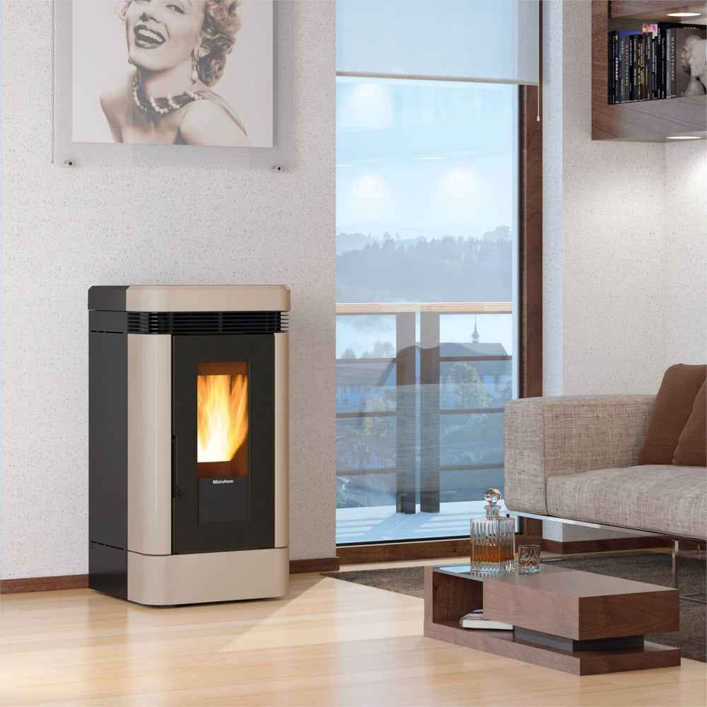 Ambientebild: Extraflame kanalisierter Pelletofen LUCIA PLUS.16 in Taupe, in modernem Wohnzimmer neben Sofa und Fenster | Klimaworld.com