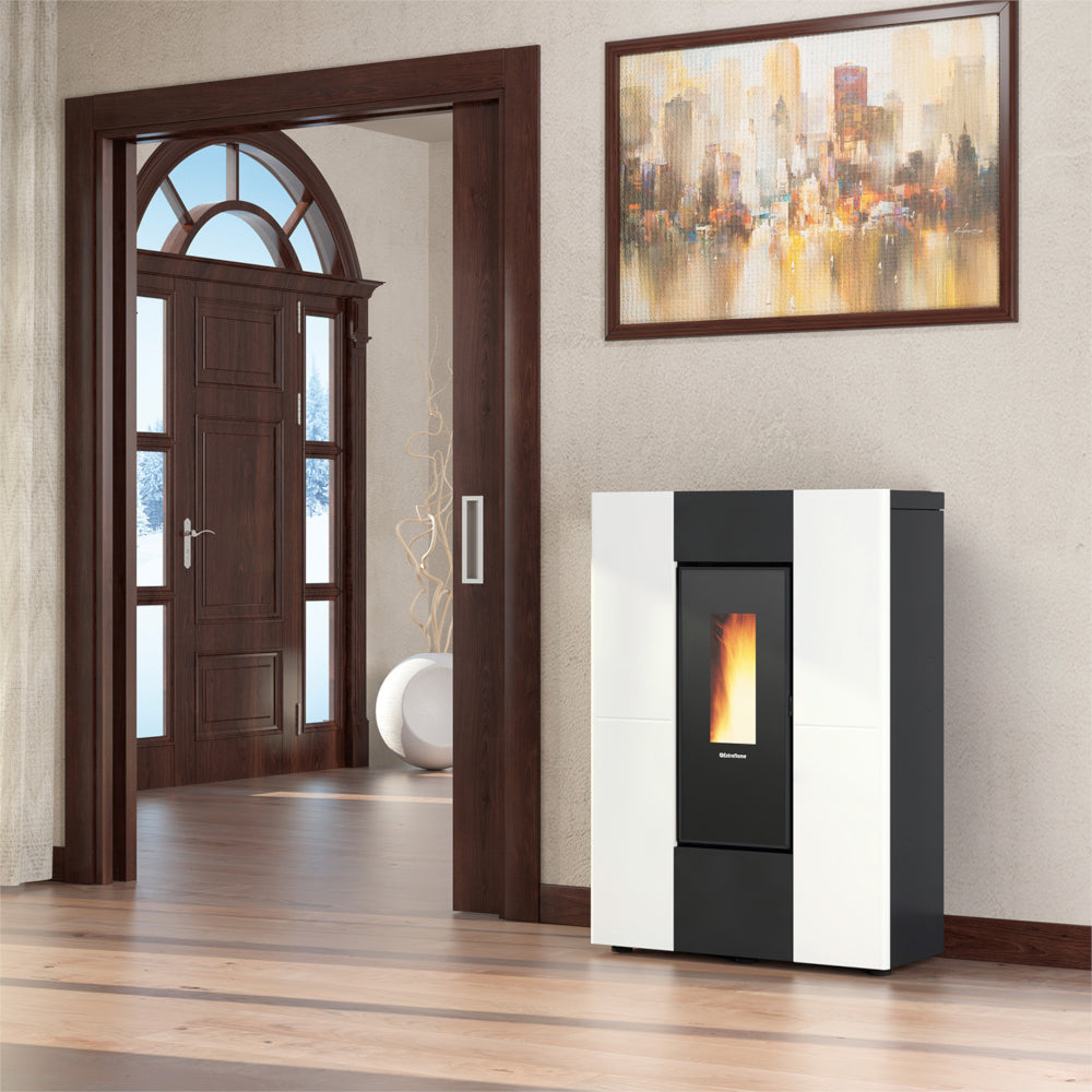 Ambientebild: schlanker Extraflame kanalisierter Pelletofen MARILENA PLUS 5.0.16 in Weiss-Schwarz vor Holztuer im Wohnraum mit Flamme | Klimaworld.com