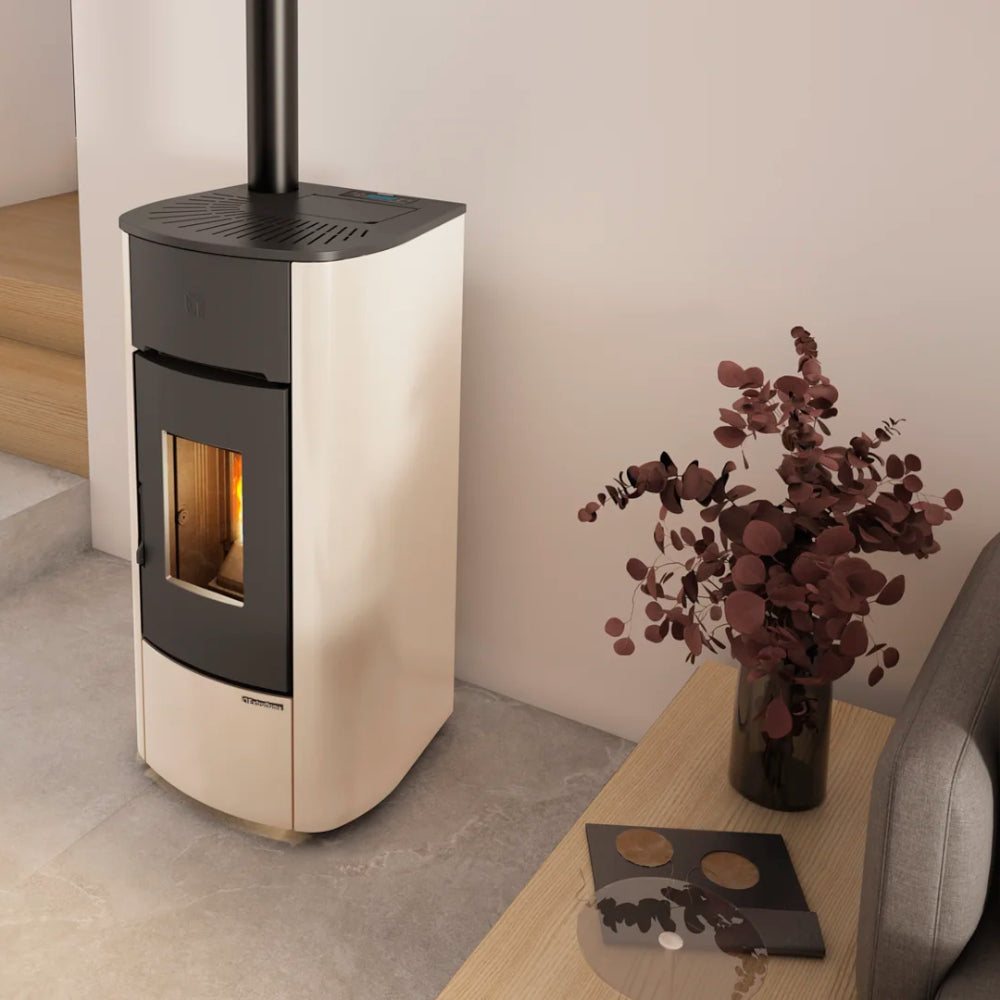 Extraflame beluefteter Pelletofen MARIELLA in Elfenbein mit schwarzer Front neben Tisch mit Vase | Klimaworld.com