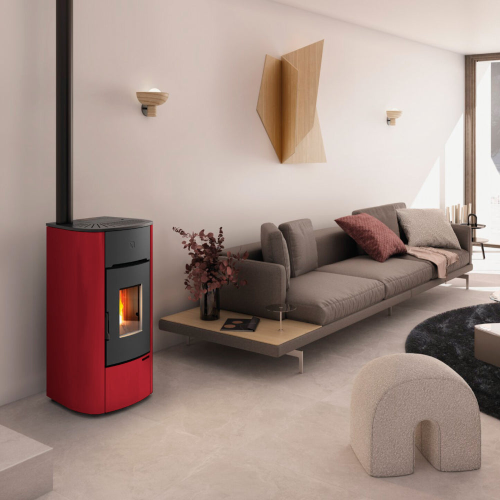 Ambientebild: Extraflame beluefteter Pelletofen MARIELLA in Bordeaux in hellem Wohnzimmer neben Sofa, Wanddeko und Couchtisch | Klimaworld.com