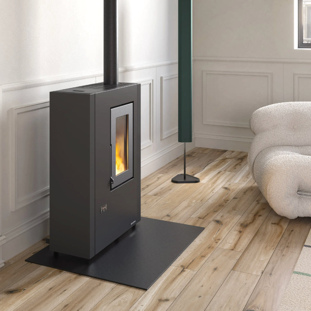 Ambientebild: schmaler Extraflame beluefteter Pelletofen LUISELLA 5.0 Maxi in Wohnraum mit stuckverzierter Wand, Holzboden, schwarzer Korpus | Klimaworld.com