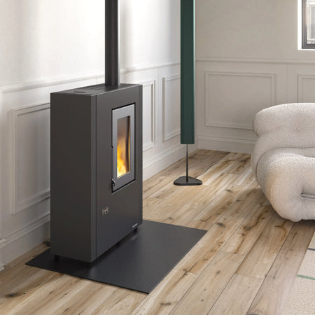 Ambientebild: schmaler Extraflame beluefteter Pelletofen LUISELLA 5.0 Maxi in Wohnraum mit stuckverzierter Wand, Holzboden, schwarzer Korpus | Klimaworld.com