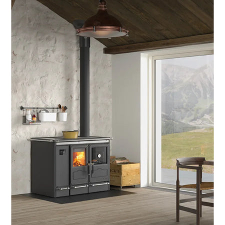La Nordica wasserfuehrender Kuechenofen SIERRA.16 schwarz, freistehend vor Steinwand, Rauchrohr nach oben | Klimaworld.com