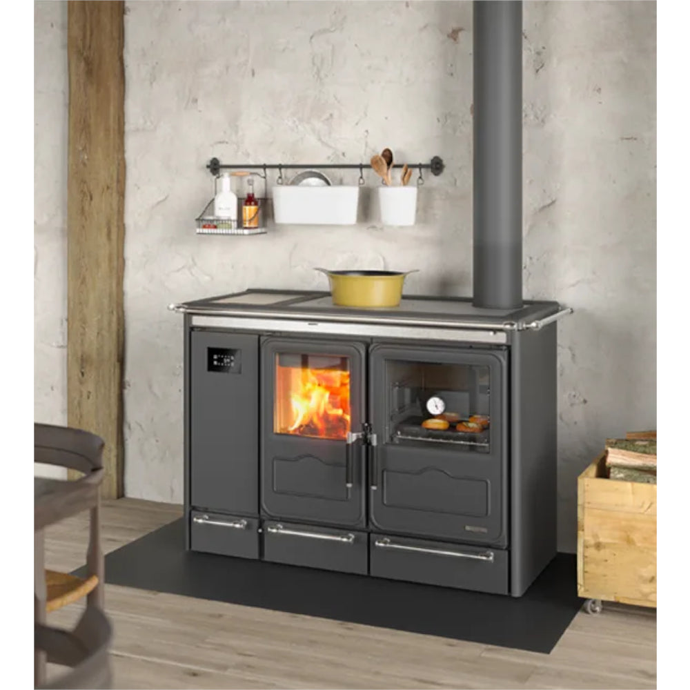 La Nordica wasserfuehrender Kuechenofen SIERRA.16 schwarz, freistehend vor Steinwand, Rauchrohr nach oben | Klimaworld.com