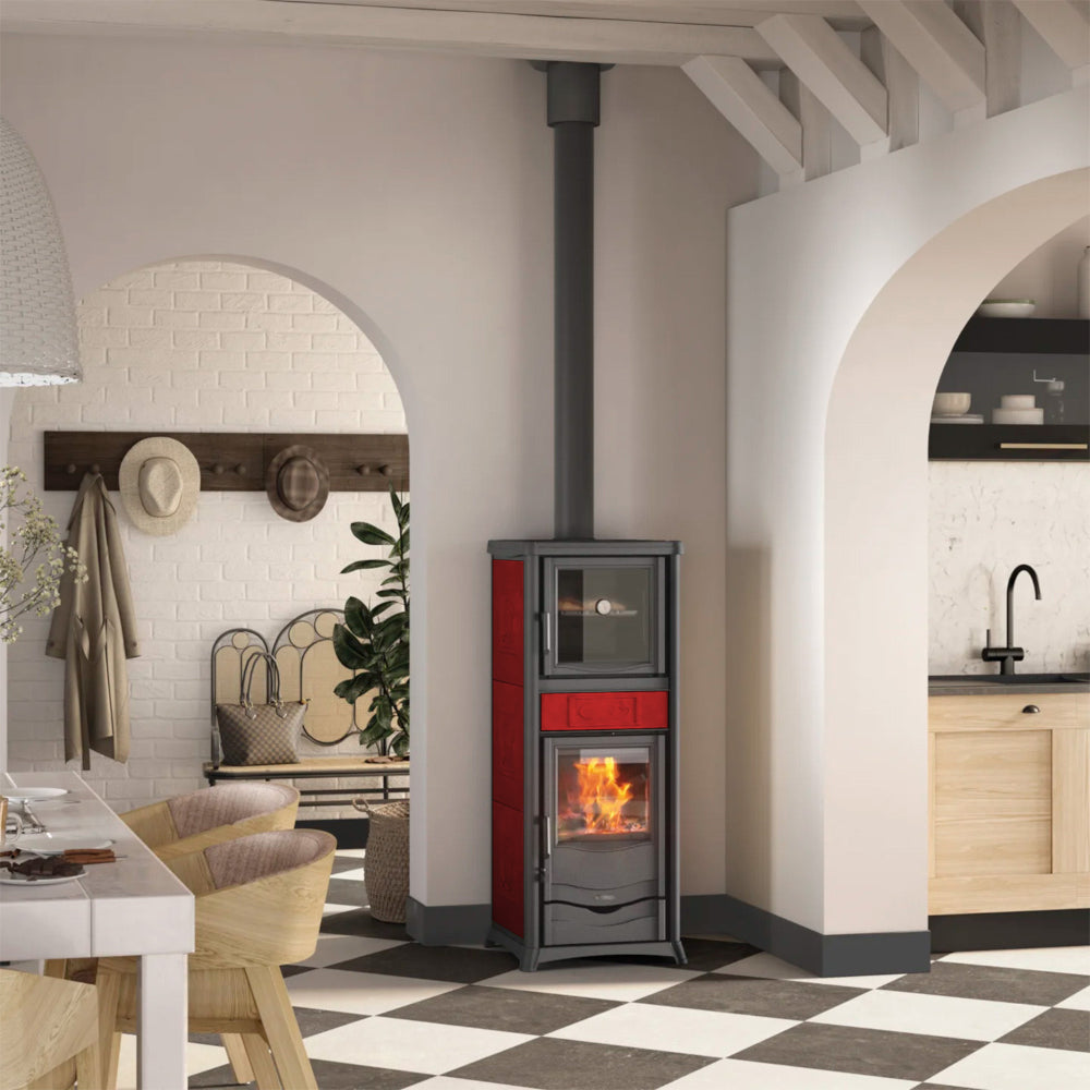 Ambientebild: Rossella Plus Forno.16 Ceramica in hellem Raum, seitlich mit Backfach und brennender Feuerkammer | Klimaworld.com