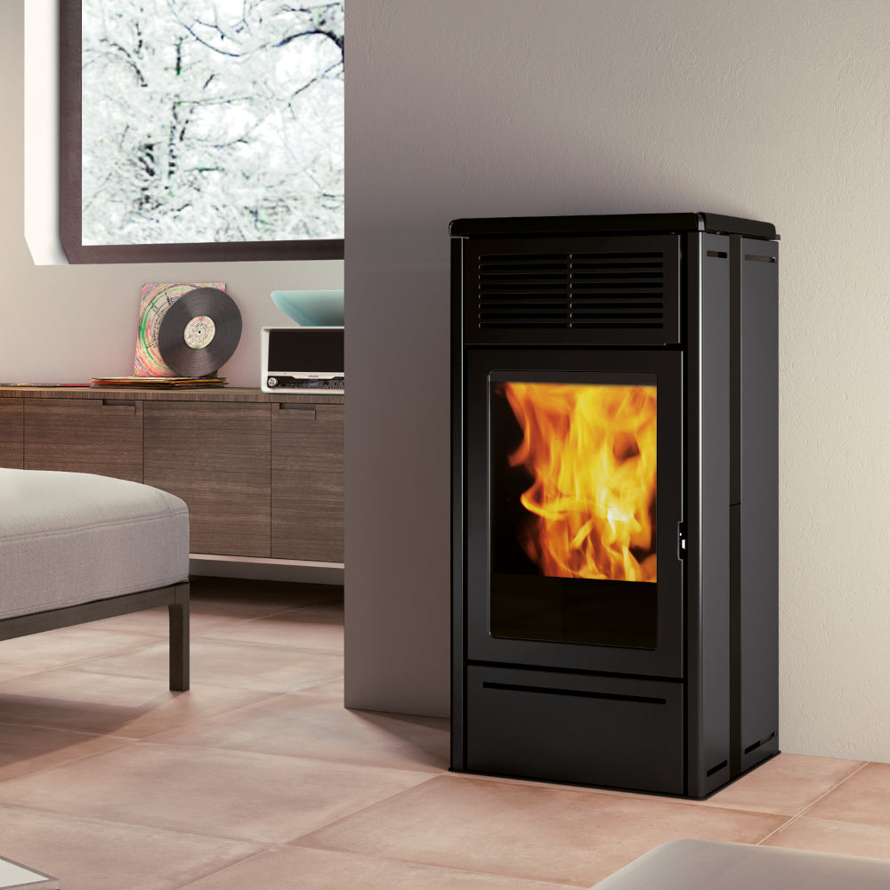Edilkamin schwarzer, eckiger Pelletofen NARA 7 EVO mit Flammenbild in modernem Wohnzimmer mit winterlichem Fenster | Klimaworld.com