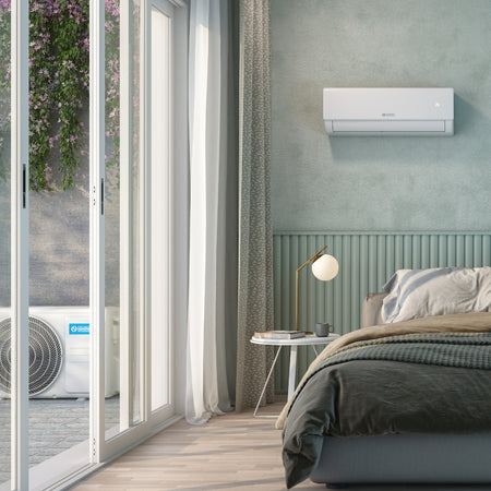 OLIMPIA SPLENDID Klimaanlage NEXYA S5 E INVERTER weisses Wandgeraet in gruenem Schlafzimmer, Aussengeraet auf Balkon sichtbar | Klimaworld.com