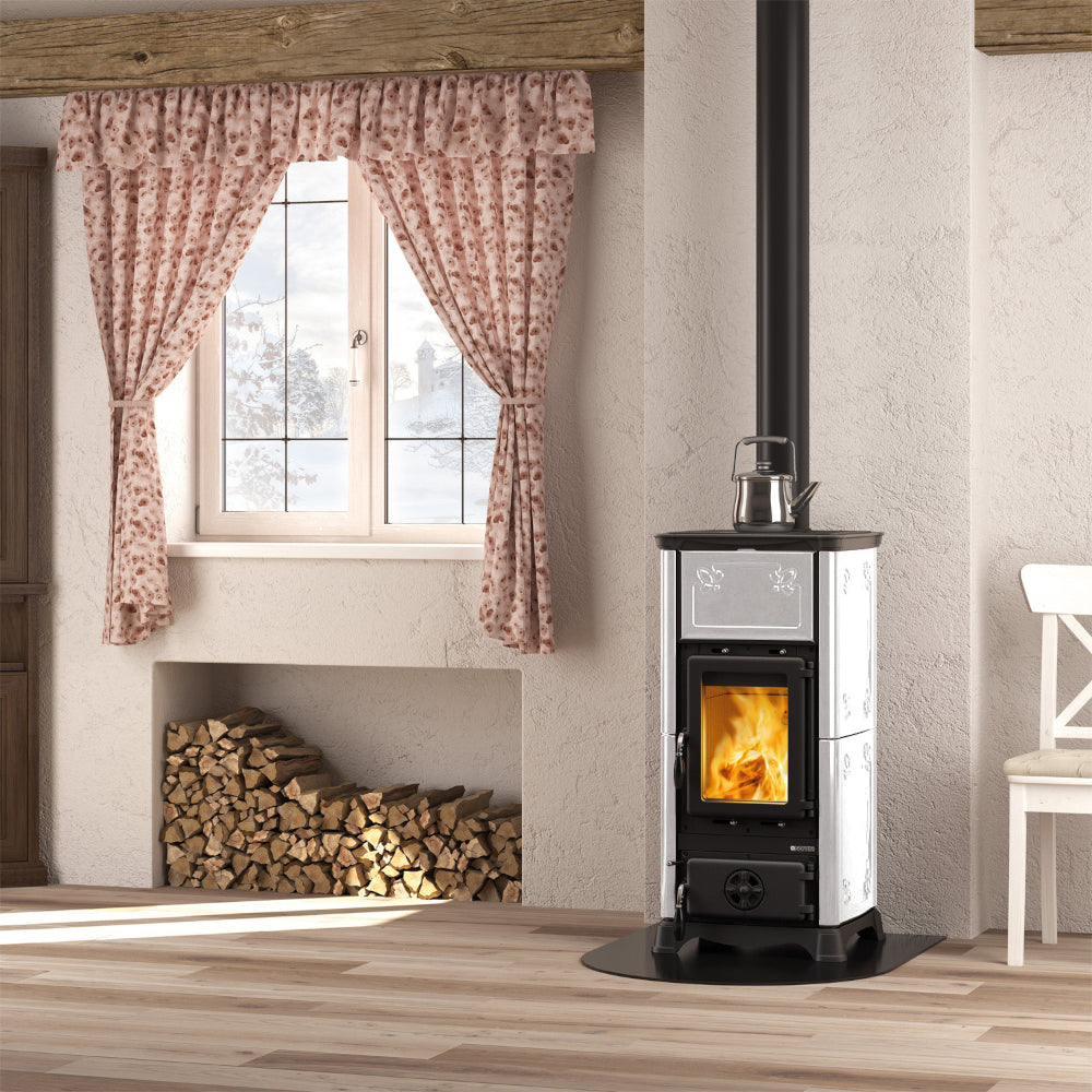 La Nordica Kaminofen EMILIANA.16 in Weiss mit Beispiel Flammenbild in gemuetlichem Zimmer | Klimaworld.com