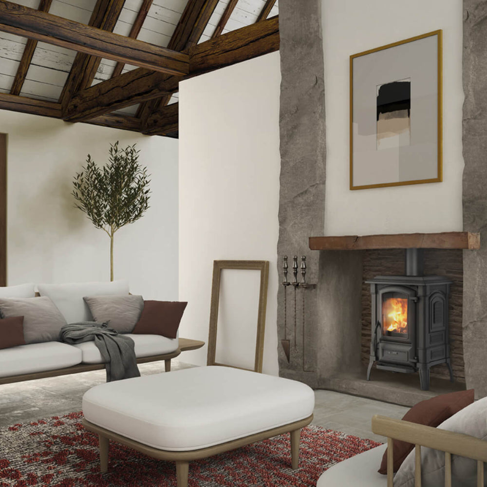 Ambientebild: La Nordica Kaminofen GIULIETTA.165 schwarzer Guss-Ofen im Kamin, Flammen hinter Glas, Wohnzimmer mit Sofa | Klimaworld.com