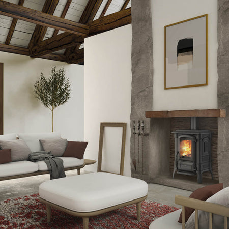 Ambientebild: La Nordica Kaminofen GIULIETTA.165 schwarzer Guss-Ofen im Kamin, Flammen hinter Glas, Wohnzimmer mit Sofa | Klimaworld.com