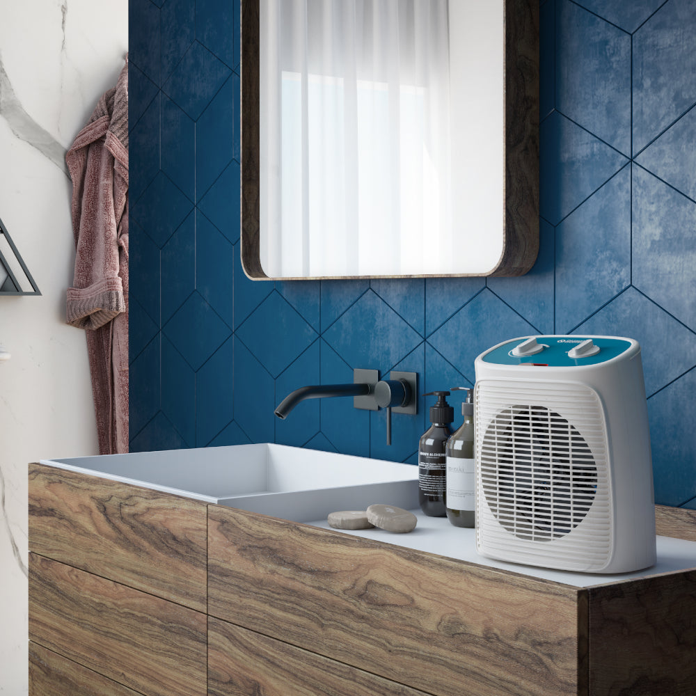 Ambientebild: Olimpia Splendid Heizluefter Caldo Rock M auf Waschtisch mit blauem Bedienfeld und Frontgitter, umgeben von Badaccessoires | Klimaworld.com
