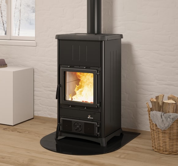 Ambientebild: La Nordica Concita 2.0 Steel Holzofen mit sichtbarem Feuer hinter Glas auf schwarzer Bodenplatte | Klimaworld.com