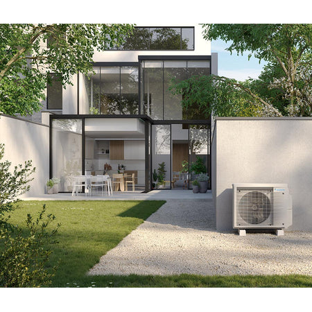 Daikin Aussengeraet 3MXM68A9 im Garten neben modernem Wohnhaus, weisses Metallgehaeuse mit Frontgitter | Klimaworld.com
